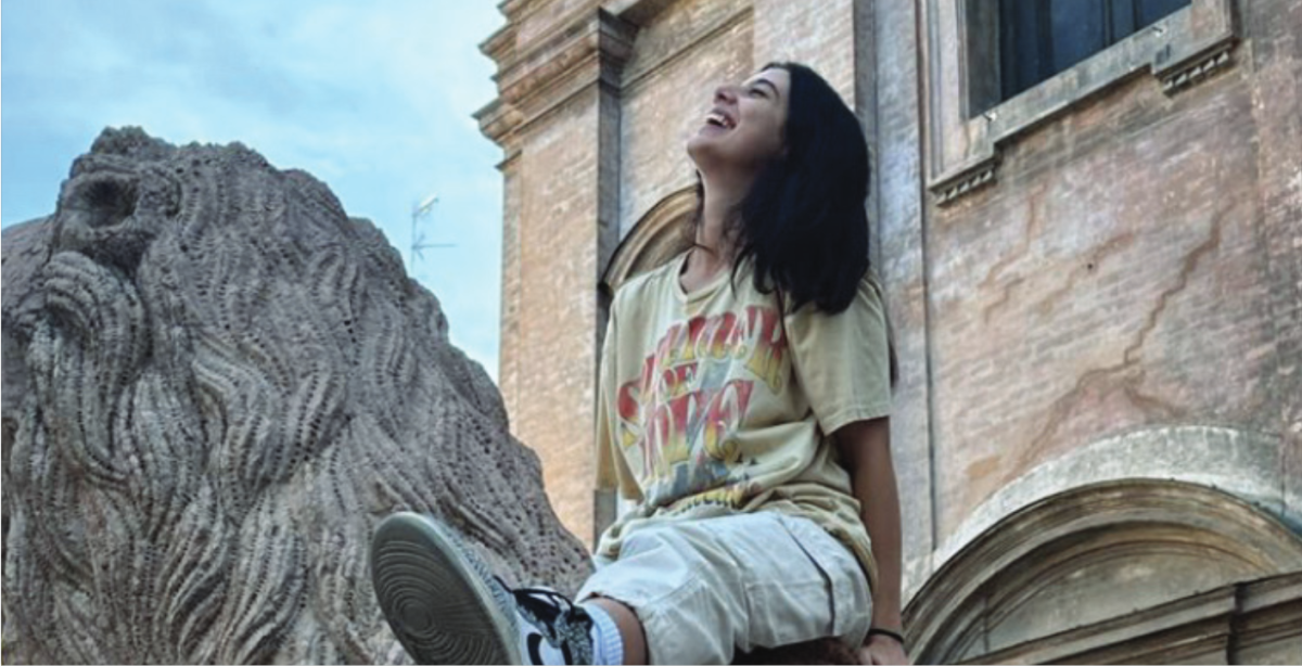 Embracing Italy: Senior Giulia Presa Vespa sits on a lion statue while touring Italy. Presa Vespa spent the past four months studying in the country, hoping to complete her semester-long academic journey abroad.